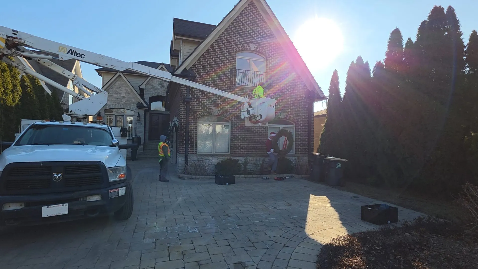 Pure Magic Holiday Lighting crew installing roofline Christmas lights with a bucket truck on a home in Burr Ridge, IL