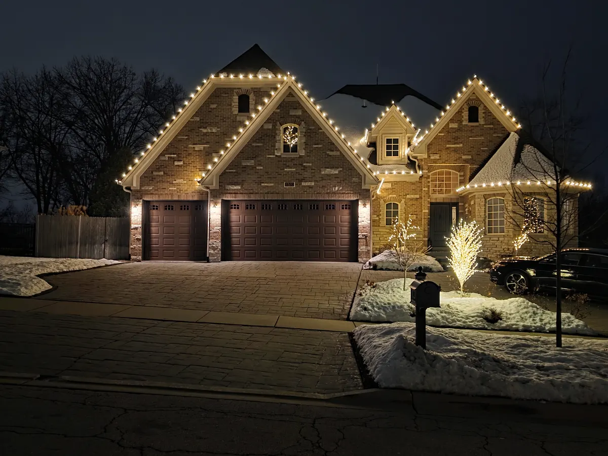 Brick home in Lemont, IL with warm white roofline Christmas lights
